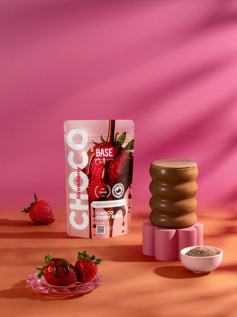 The Base Choco Strawberry pouch with strawberries and a chocolate drink on a pink background